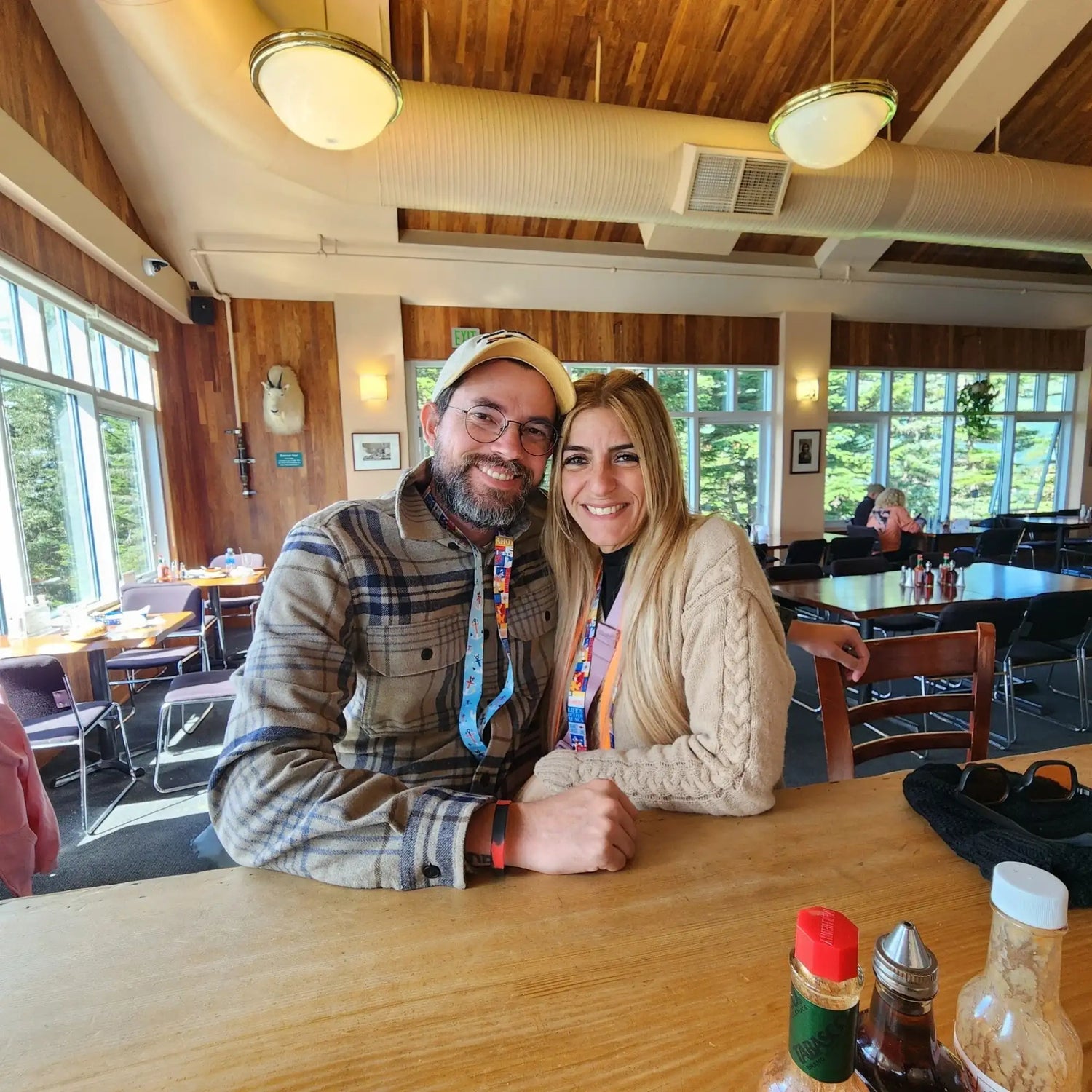 The man is wearing a beige and blue plaid flannel shirt with buttoned cuffs.